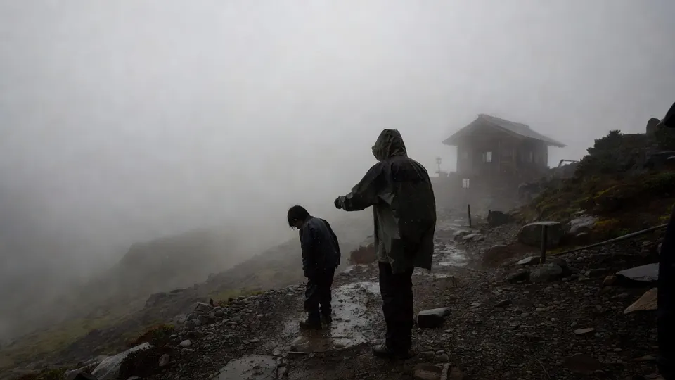 Wandelaars lopen in mist en regen over Mount Fuji