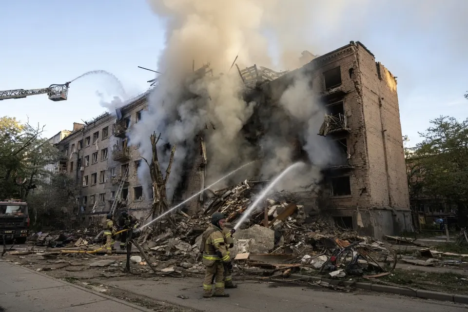 Brandweerlieden blussen een verwoest gebouw in Oekraïne na een Russische aanval