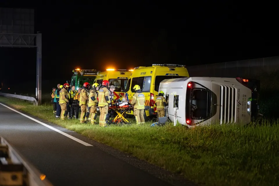 Hulpdiensten verlenen hulp bij de gekantelde Oostenrijkse touringcar op de A28 bij Wezep