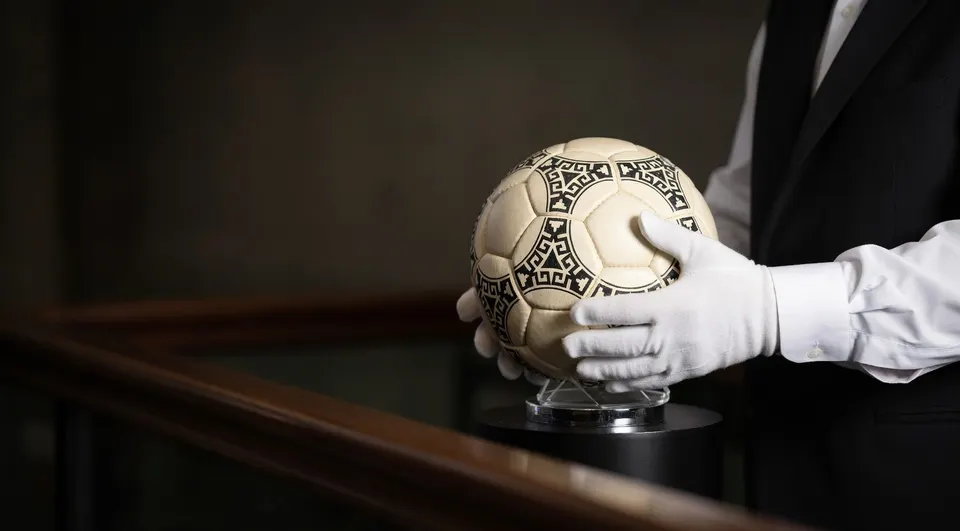 De aan Diego Maradona verbonden ‘hand van God’-bal wordt vastgehouden tijdens een veiling