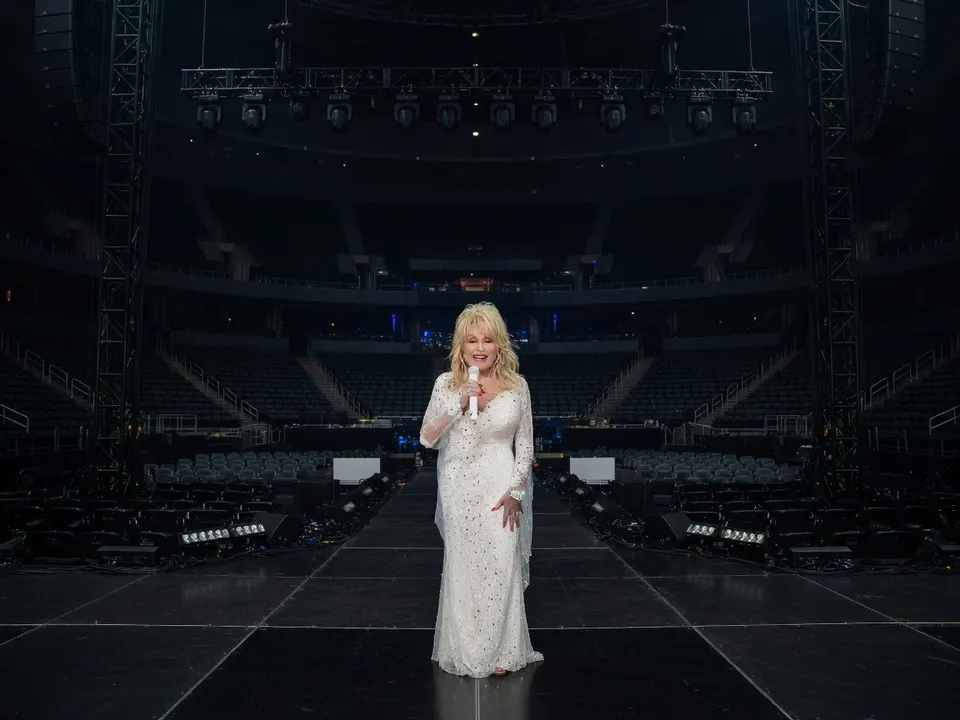 Dolly Parton staat op een podium in een lege concertzaal