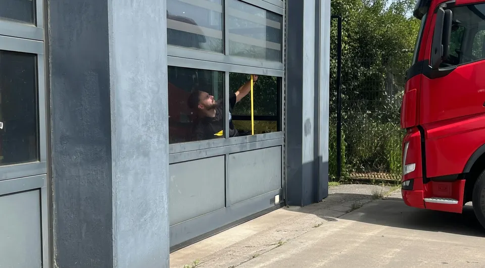 Een brandweerwagen staat bij de beschadigde roldeur van de brandweerkazerne in Benthuizen