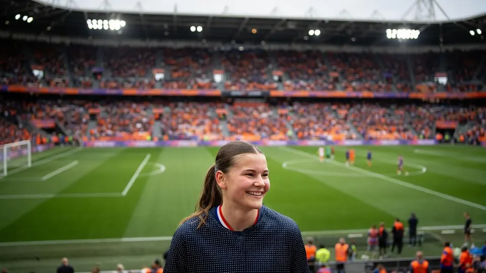 Renee van Asten poseert voor een voetbalveld van Ajax