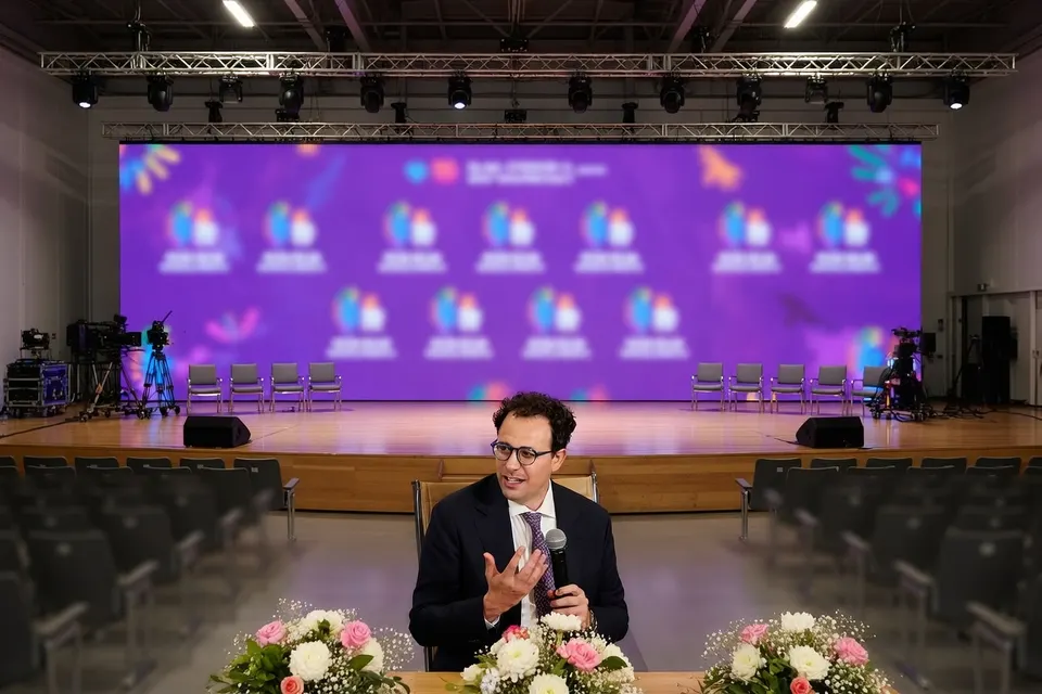 Een man spreekt tijdens een evenement op een podium