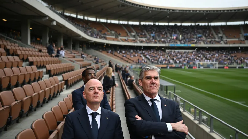 KNVB-voorzitter Frank Paauw en een man op de tribune van een voetbalstadion