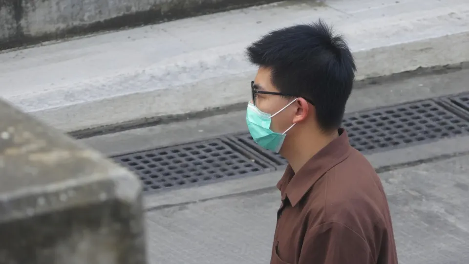 Joshua Wong draagt een mondkapje tijdens een wandeling