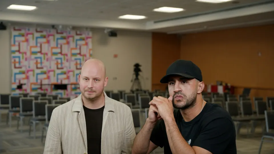 Badr Hari zit naast zijn advocaat in een ruimte met stoelen