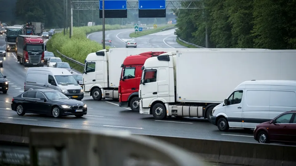 Vrachtwagens en personenauto's staan vast op een drukke weg