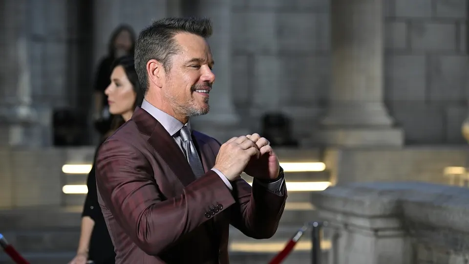 Een man poseert bij een evenement rond de film The Odyssey