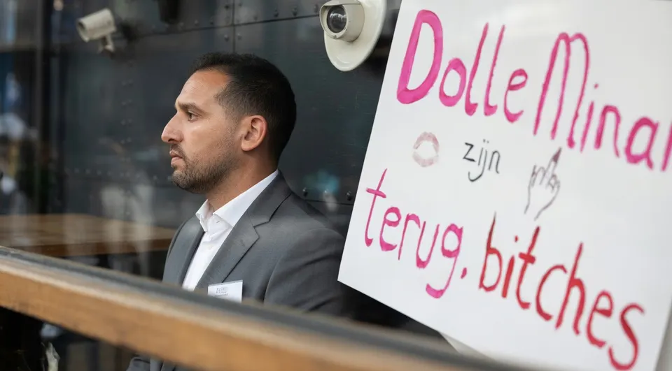 Een demonstrant bij een protestbord van Dolle Mina's tegen het optreden van Ali B in Vinkeveen