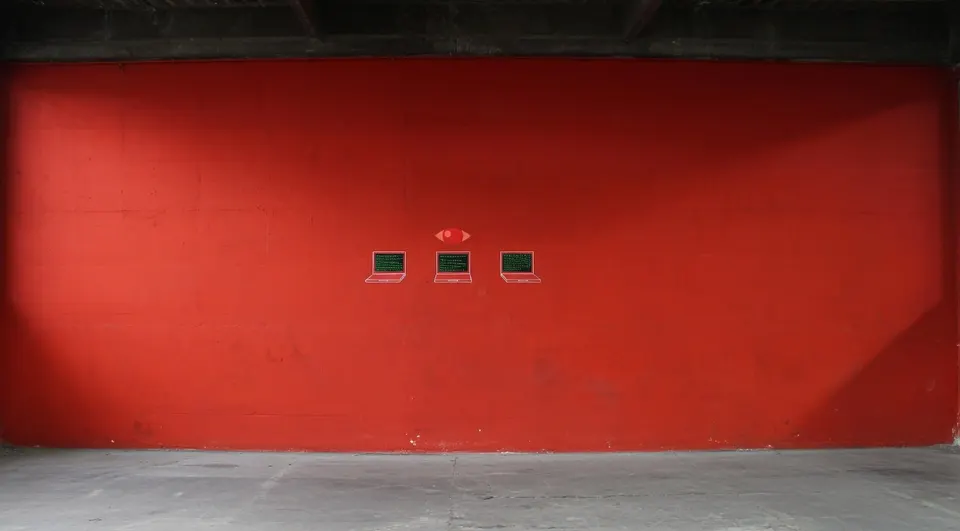 Drie kleine schermen op een rode muur