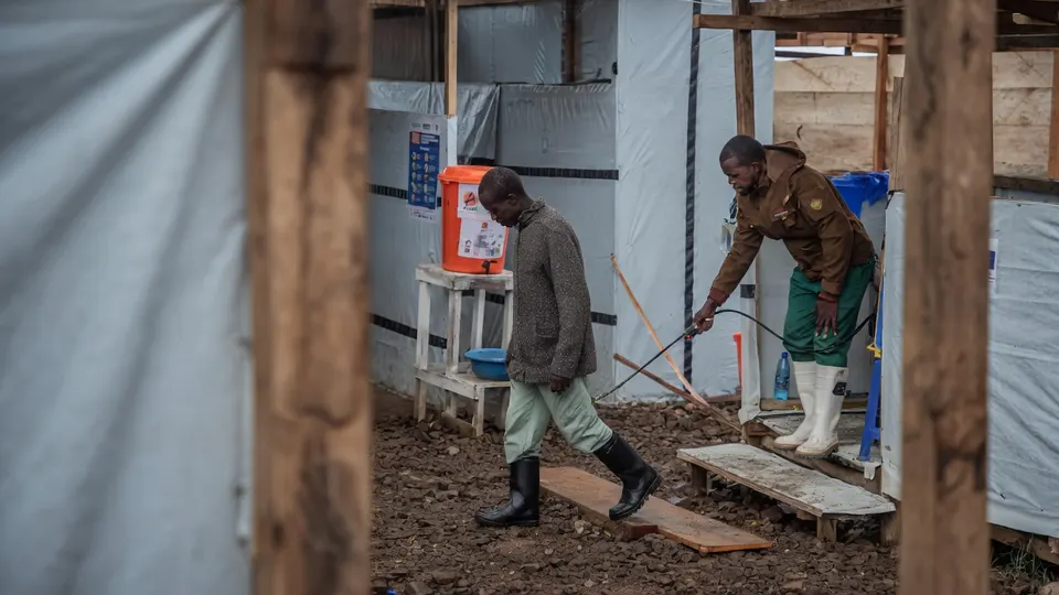 Hulpverleners lopen bij een ebolabehandelcentrum in Congo