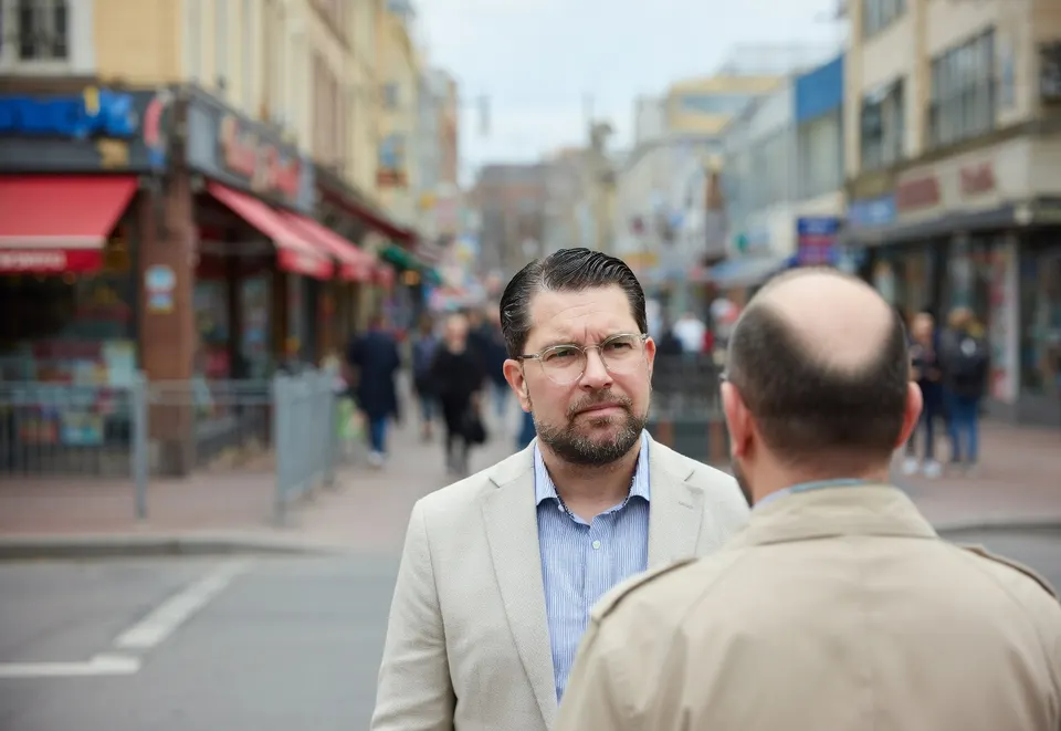 Premier Ulf Kristersson spreekt in een Zweedse winkelstraat met een man