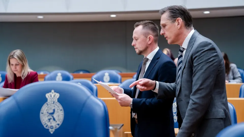 Twee mannen bekijken documenten in de Tweede Kamer