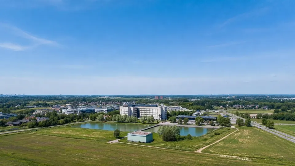 Luchtbeeld van een bedrijventerrein met waterpartijen en groene velden