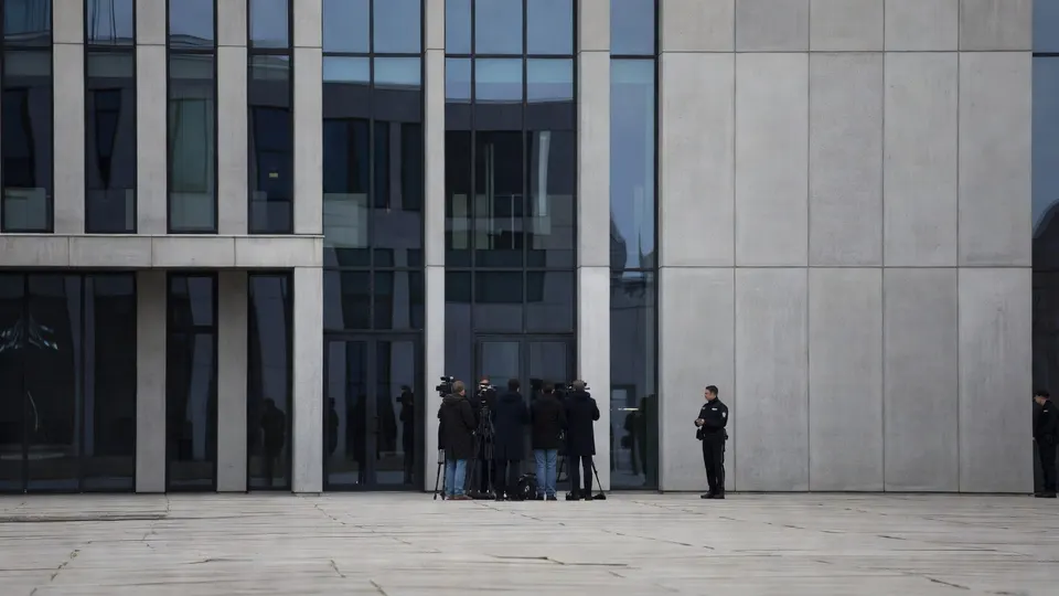 Journalisten en beveiligers bij de rechtbank voorafgaand aan de pro-formazitting