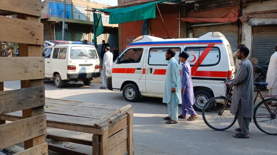 Hulpdiensten en omstanders bij een ambulance na de aanslag op een moskeeterrein in Kohat