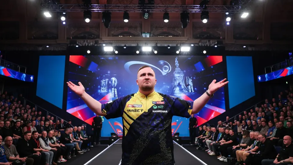 Luke Littler op het podium tijdens een dartstoernooi