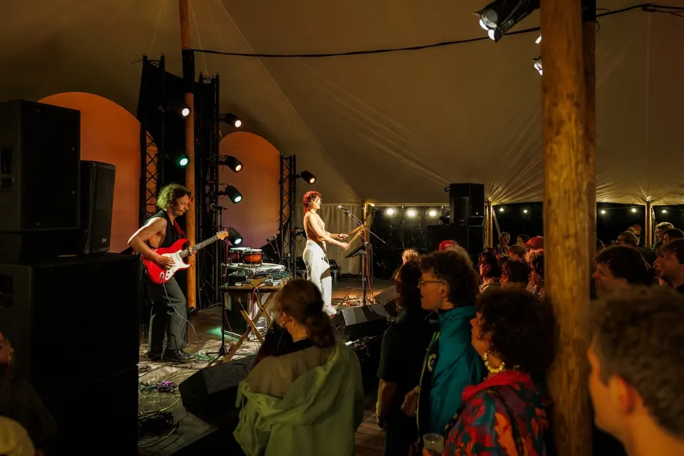 Muzikanten treden op voor publiek tijdens Noorderzon in een festivaltent