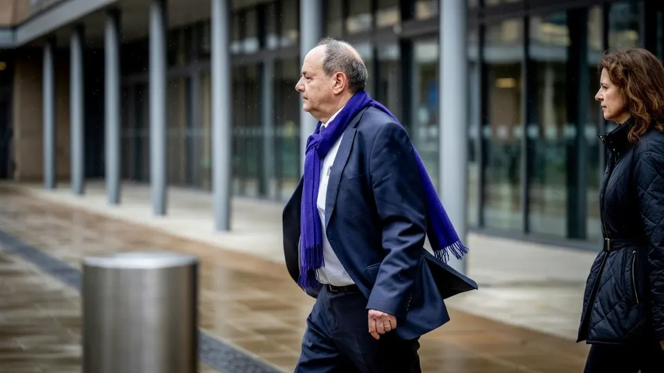 Minister Vijlbrief loopt met een vrouw langs een kantoorgebouw