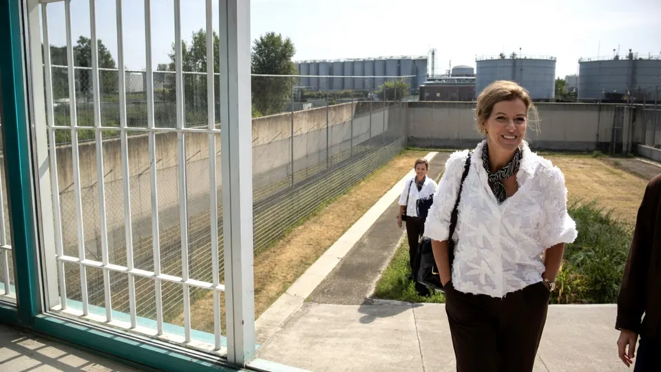 Staatssecretaris Claudia van Bruggen loopt bij een gevangenis