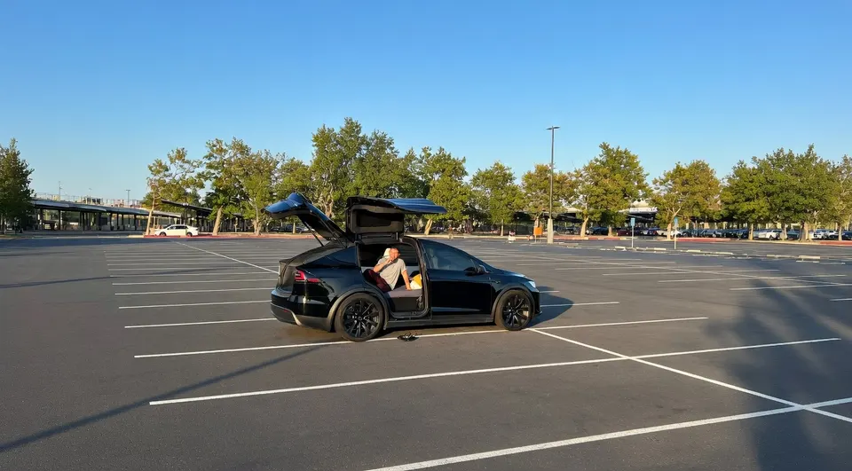 Nico Murillo zit in zijn Tesla Model X op een parkeerterrein