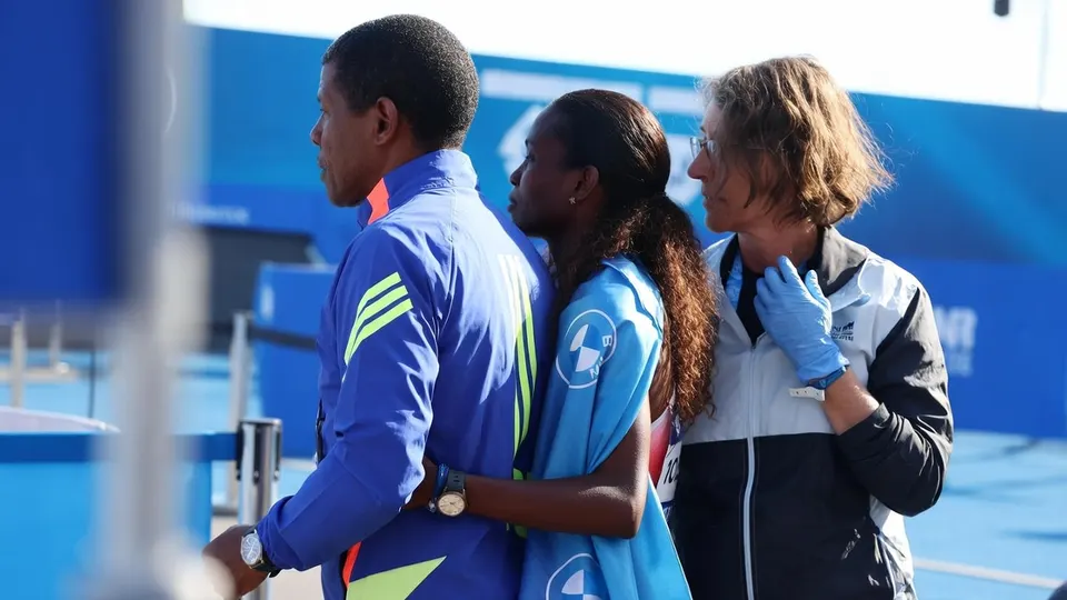 Tigst Assefa wordt na haar overwinning in Berlijn begeleid