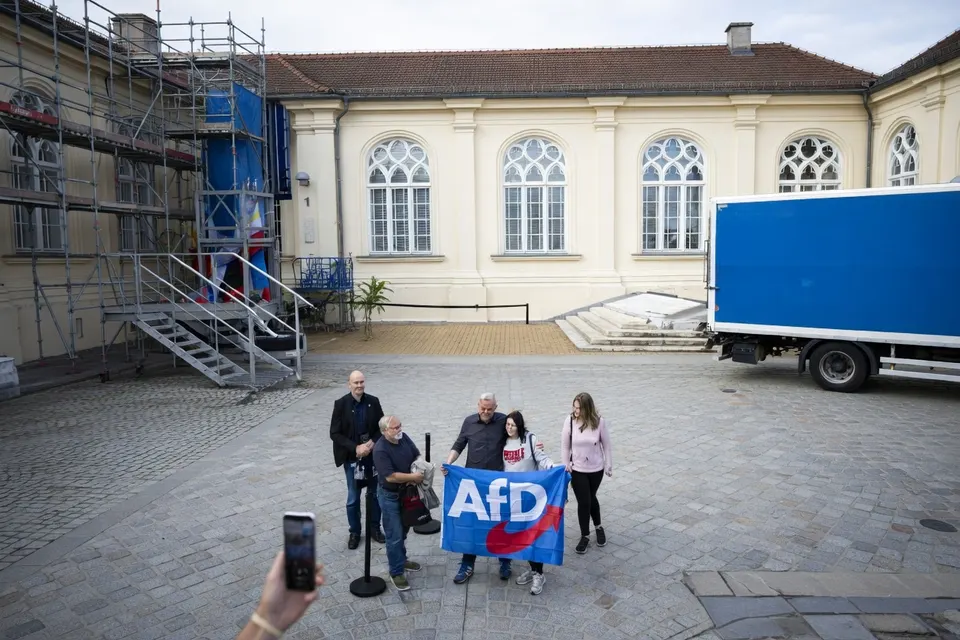 Aanhangers van de AfD staan met een partijsjaal voor een stembureau in Nedersaksen