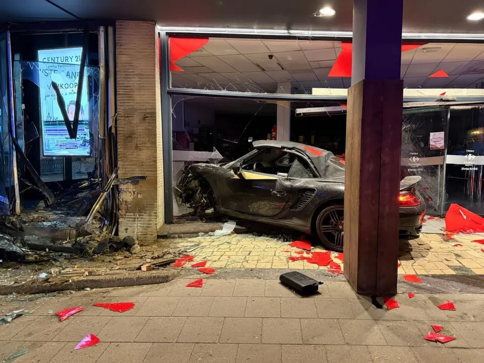 Een zwarte Porsche staat na de crash in de ingang van een Carrefour-supermarkt in Avelgem