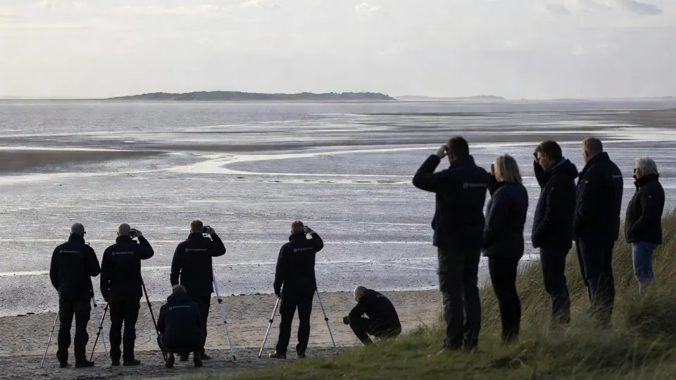 Mensen kijken uit over het wad bij Schiermonnikoog, waar mogelijk delen voor wandelaars worden afgesloten