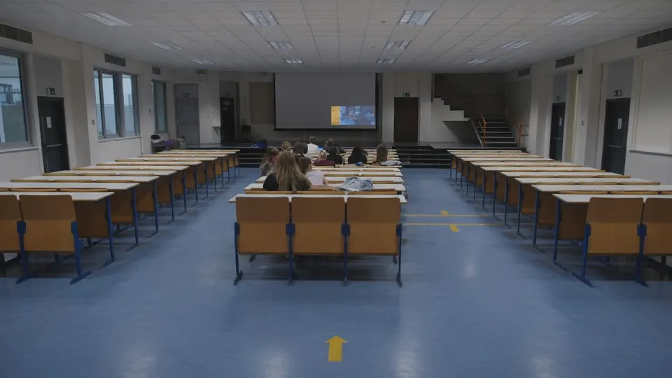 Collegezaal van de UvA waar studenten zonder laptops, telefoons en tablets les volgen