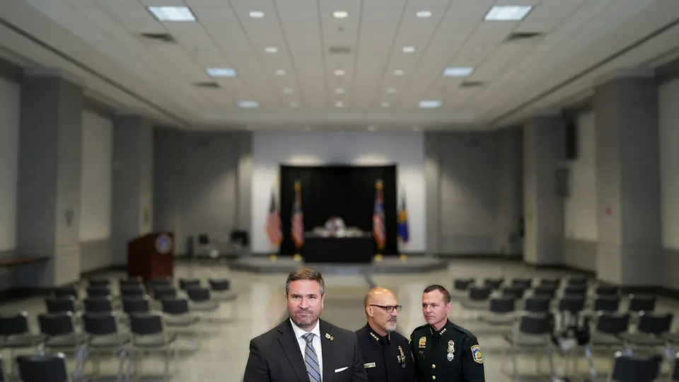 Andrew Bailey met twee FBI-functionarissen in een zaal