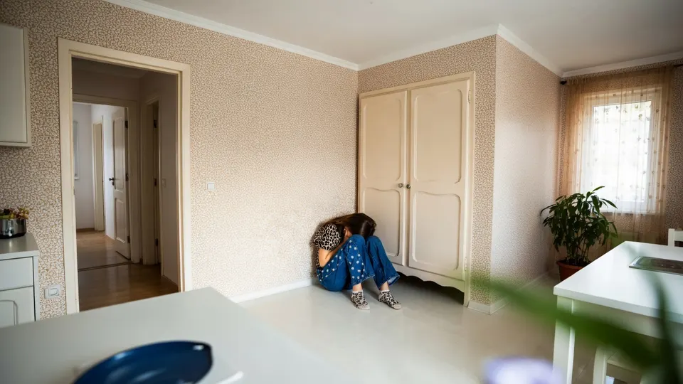 Kind zit op de grond in een kamer