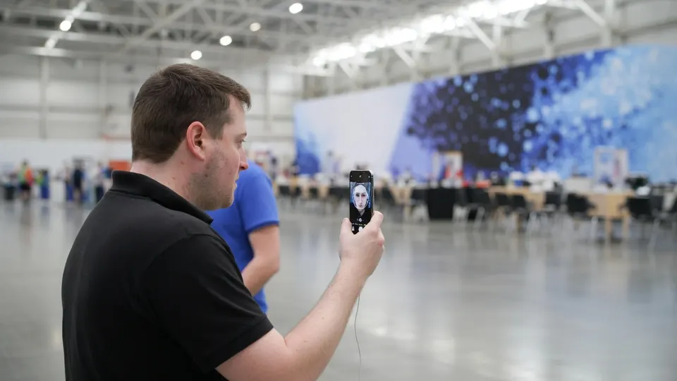 Een man filmt een smartphone in een grote hal