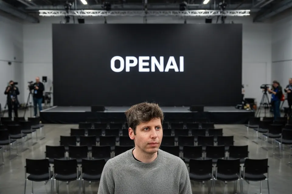 Sam Altman in een zaal met het OpenAI-logo
