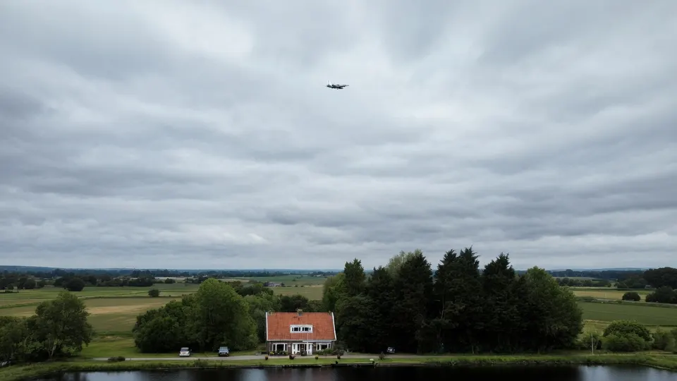 Een vliegtuig vliegt boven een woning in het landelijke gebied rond Schiphol
