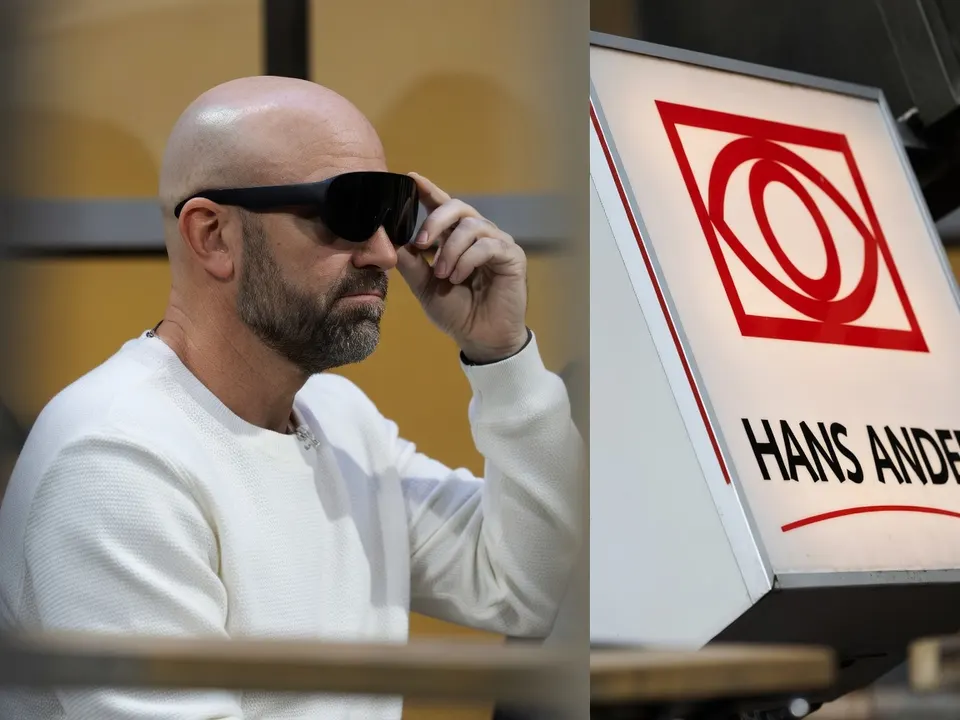 Een man draagt een Meta-bril naast een bord van Hans Anders