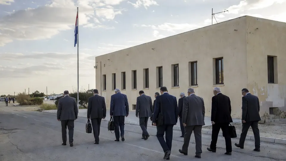 Nederlandse ambassademedewerkers lopen bij een gebouw op de Westelijke Jordaanoever