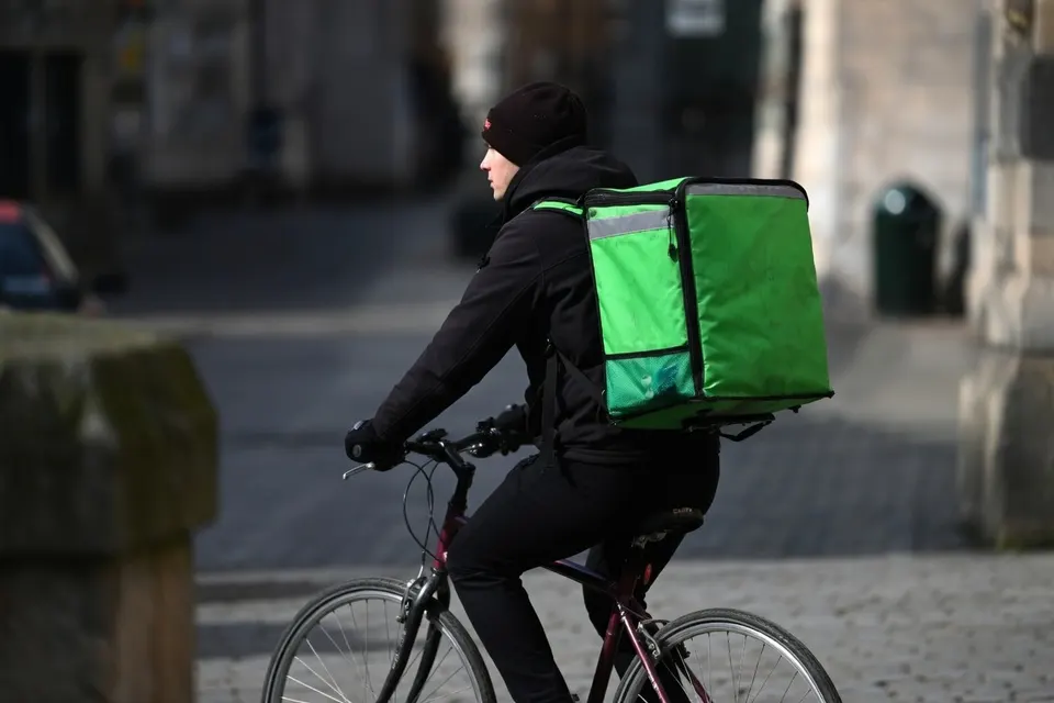 Maaltijdbezorger op de fiets met een grote bezorgtas