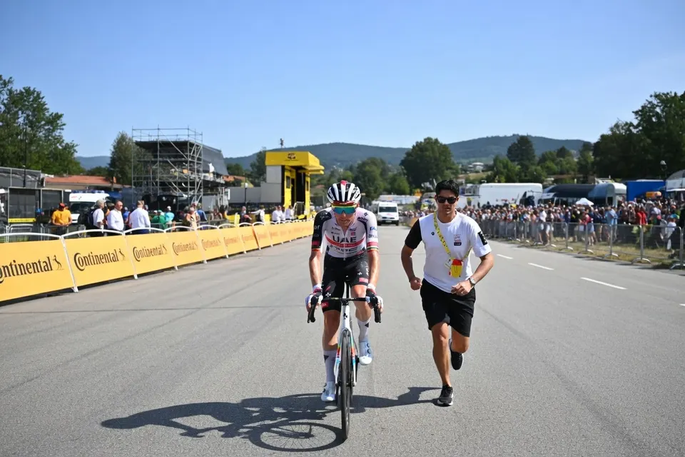 De zieke Tim Wellens rijdt, begeleid door een ploeggenoot, naar de finish van de achttiende Tour-etappe