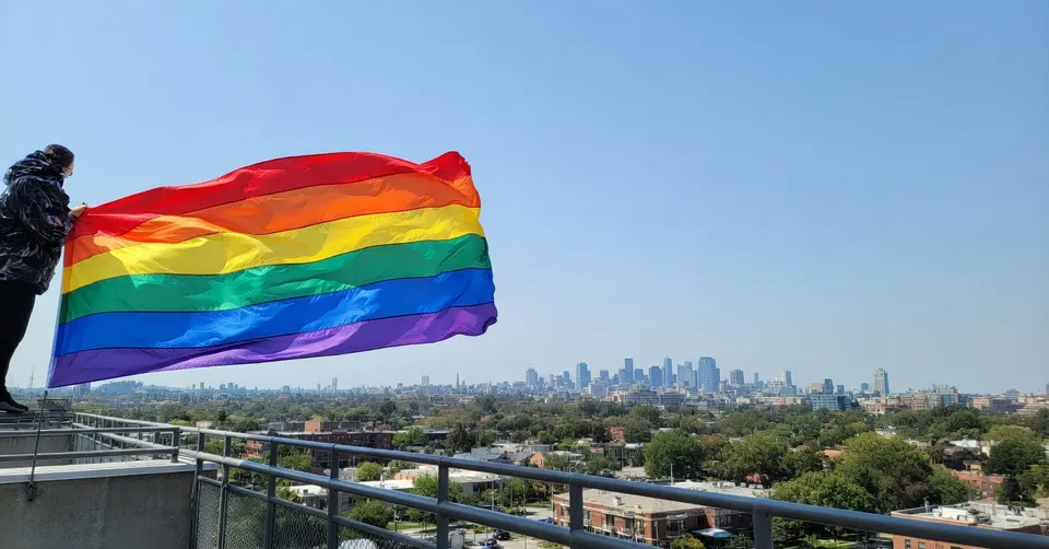 Regenboogvlag wappert boven een stad