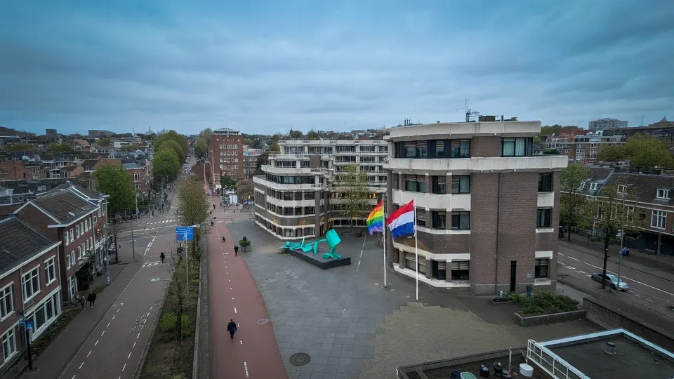 Regenboogvlaggen wapperen bij een overheidsgebouw in aanloop naar Coming-Outdag