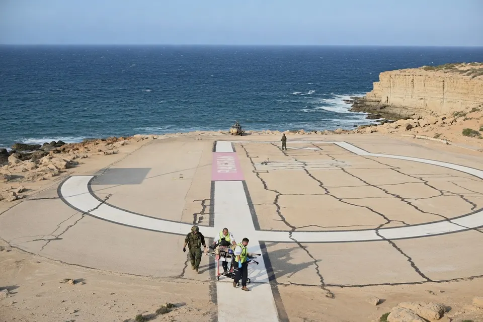Mensen lopen over een betonnen platform aan de kust van Israël