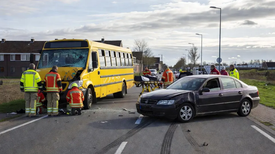 Schoolbus en auto botsen in het Duitse Epe, hulpverleners ontfermen zich over de gewonden