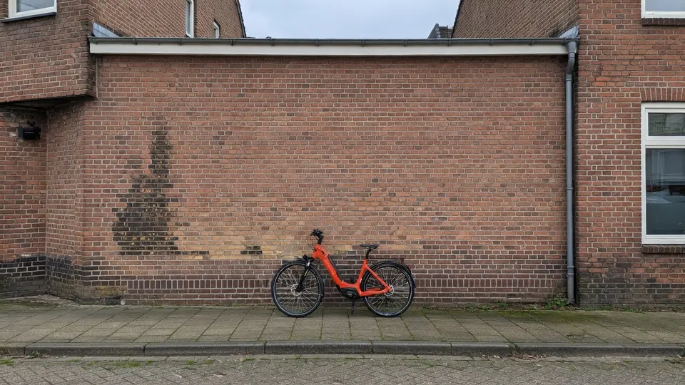 Een Sparta-fiets staat tegen een bakstenen muur