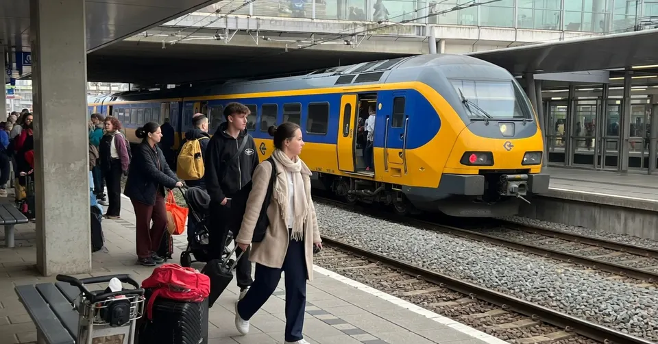 Reizigers wachten op een trein op een druk perron in Utrecht