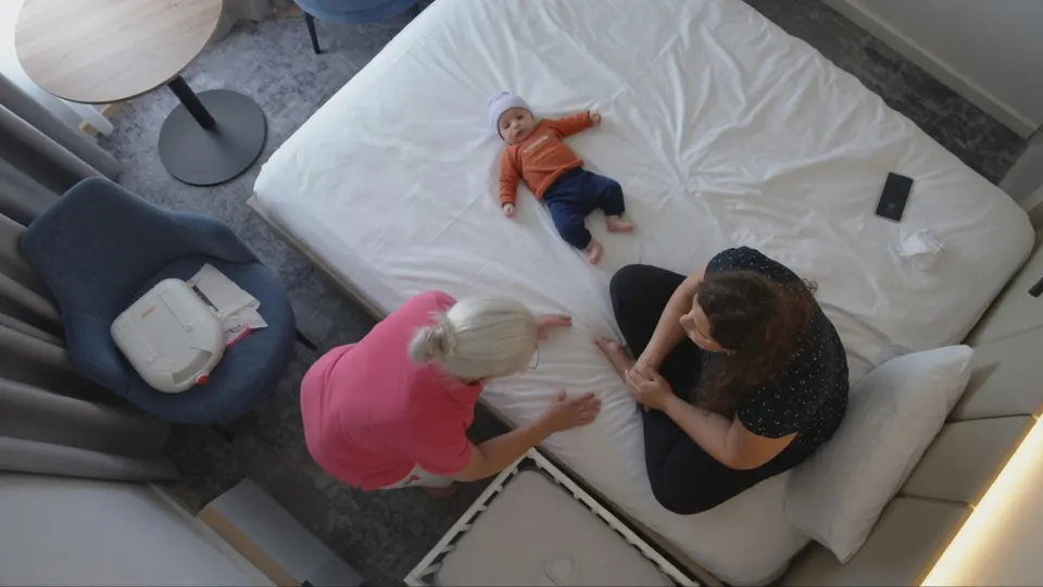 Een kraamverzorgende helpt een moeder en haar baby in een kraamhotel
