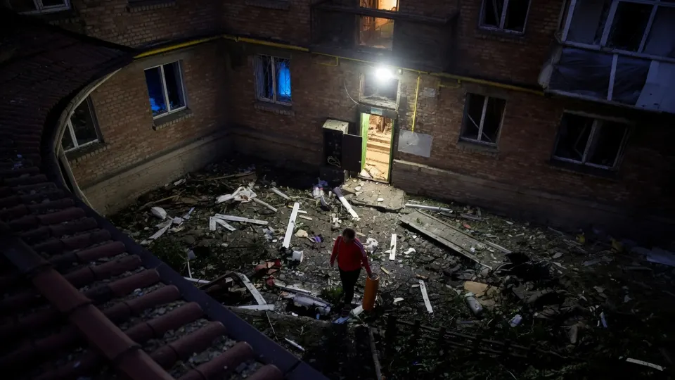 Hulpverleners onderzoeken een beschadigde binnenplaats in Kyiv na een Russische raketaanval