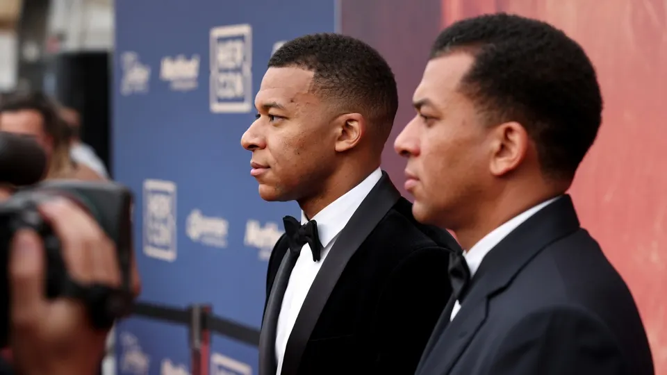 Kylian Mbappé en een onbekende man tijdens een evenement