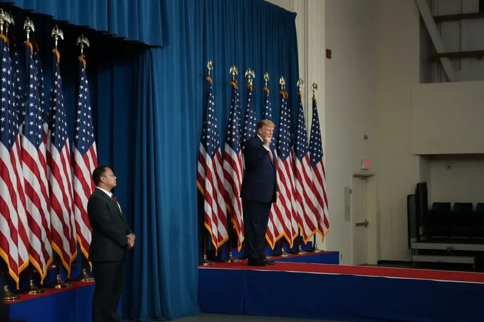 President Donald Trump tijdens een bijeenkomst met Amerikaanse vlaggen